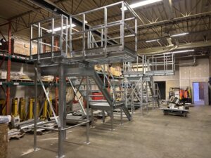 Multiple galvanized truck washing platforms staged in a warehouse, featuring OSHA-approved staircases and swing decks.