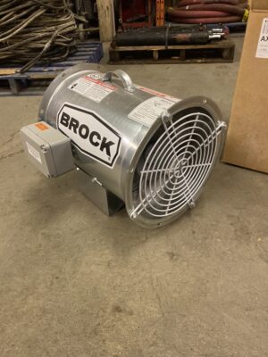 New 12-inch Brock axial fan with galvanized housing and protective front grille resting on a shop floor