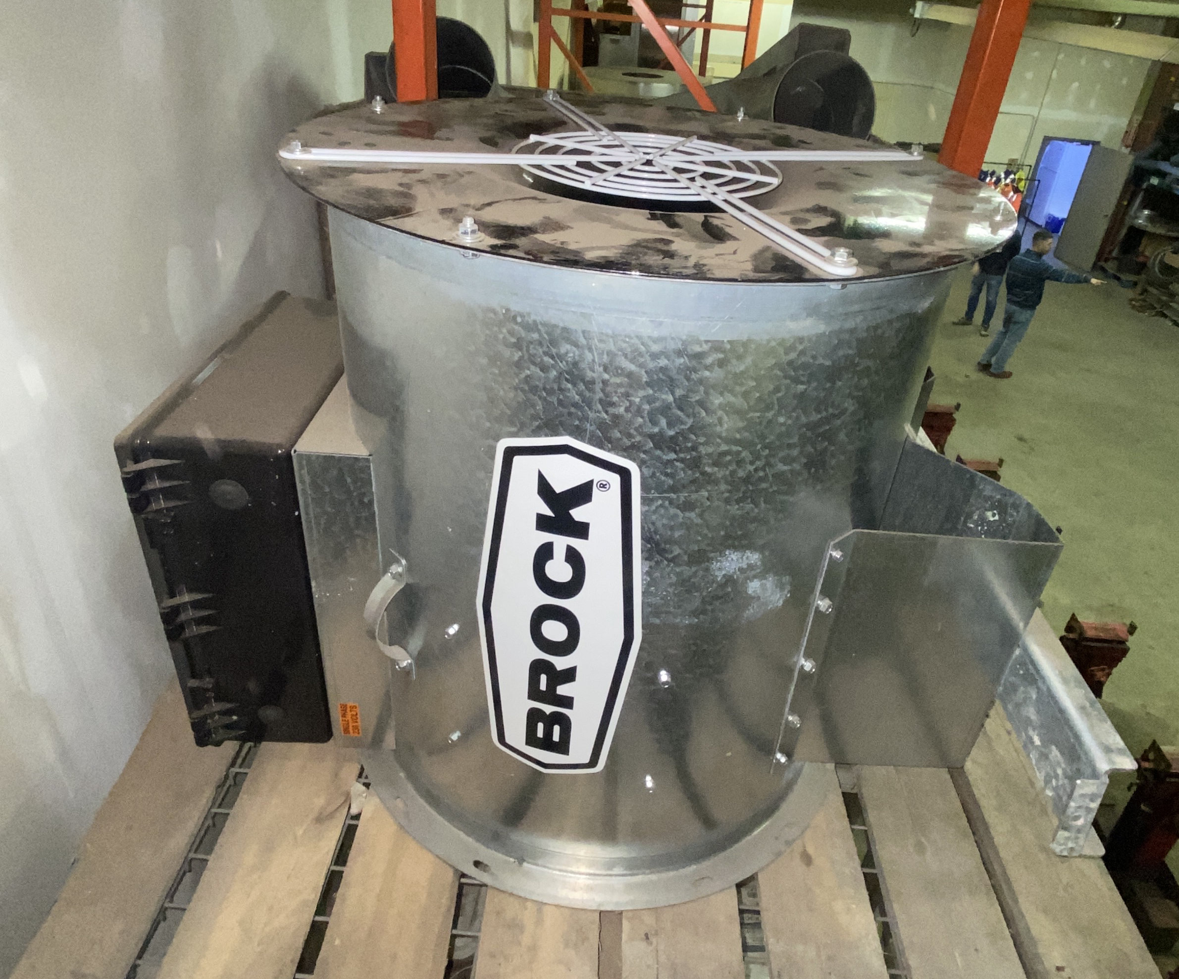 24-inch Brock in-line centrifugal grain bin fan resting on a pallet inside a workshop