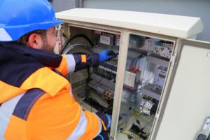 Electrician by a fusebox using a multimeter