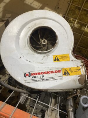 Heavily used Kongskilde FRL15 blower housing showing exposed impeller and missing body band.
