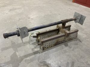 Used Brock in‑line heater burner weldment with perforated burner chambers and gas piping resting on a shop floor.