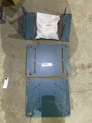 Dodge TA1M motor mount kit with steel plates, brackets, and hardware laid out on a concrete floor.