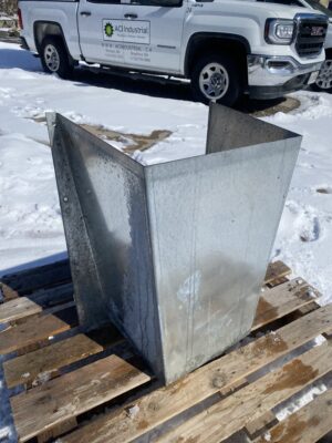 Galvanized Brock side draw baffle panel resting flat on a wooden pallet outdoors.