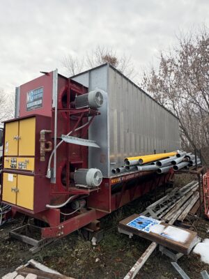 Exterior view of an MC Grain Dryer model 975 showing the drying column, fans, and burner housing.