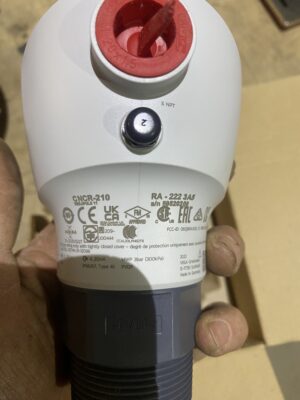 Close‑up of the CNCR‑210 radar sensor label showing certifications, model information, and threaded process connection.